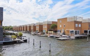 a group of boats docked in a river next to buildings at Cairo in Almere