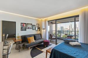 Cet appartement comprend une chambre avec un lit et un canapé ainsi qu'un salon. dans l'établissement Magníficos Ap Luxo - 43mts e 63mts, 1 ou 2 Qtos, à São Paulo