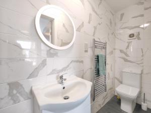 a white bathroom with a sink and a mirror at Charming Holiday Studio in Hazel Grove - Self Catering Apartment 2 in Hazel Grove