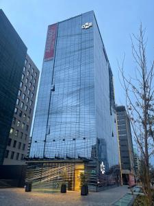 un grande edificio in vetro con un segnale acustico sopra di One Manquehue Aparthotel a Santiago