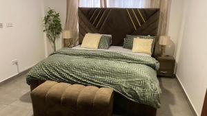 Accra Luxury apartments at Oasis Park Residences في آكرا: غرفة نوم بسرير كبير مع اللوح الخشبي