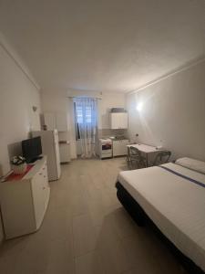 een grote kamer met een bed en een keuken met een keuken bij Monolocale via centrale in Sorso