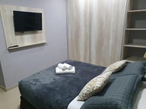 1 dormitorio con 1 cama y 2 toallas plegables. en Martina Apart en Puerto Iguazú