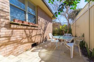 シドニーにあるFamily Stay with Idyllic Sun-drenched Courtyardの家の側にテーブルと椅子付きのパティオ