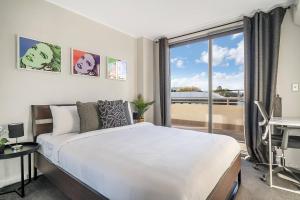 Ένα ή περισσότερα κρεβάτια σε δωμάτιο στο 'Redfern Horizons' An Unforgettable Rooftop Escape
