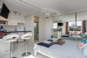 Un dormitorio con una cama y una cocina con encimera. en 'Bondi Fairview' Coastal Panorama with Balcony, en Sídney