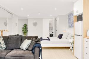 a living room with a couch and a bed at 'The Crows Nest' Spacious Studio with Balcony in Sydney