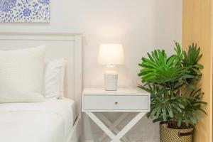 a bedroom with a bed with a lamp and a plant at 'The Crows Nest' Spacious Studio with Balcony in Sydney