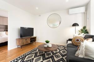a living room with a couch and a tv at Live Like a Sydney Local in Trendy Marrickville in Sydney