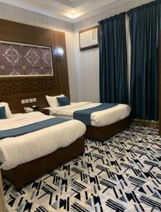 pokój hotelowy z 2 łóżkami i dywanem w obiekcie قست العصر للشقق المخدومة w mieście Dżudda