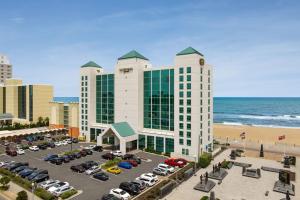 a hotel with a parking lot next to the beach at Courtyard Virginia Beach Oceanfront/South in Virginia Beach