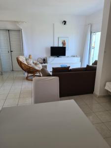a living room with a couch and a tv at Christina's panoramic view appartment in Polychrono
