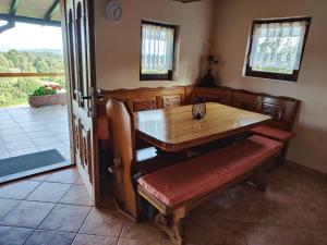 uma mesa de jantar com bancos e uma mesa e cadeiras de madeira em Holiday house Panorama em Ozalj