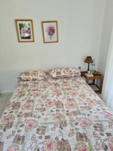 a bedroom with a bed with a floral quilt on it at Christina's panoramic view appartment in Polychrono