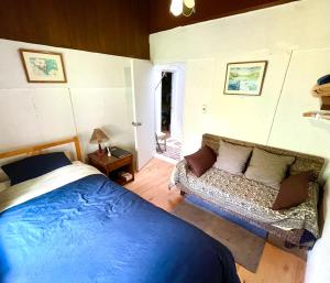 a bedroom with a bed and a couch in it at Gallery HARA and guest house in Hara