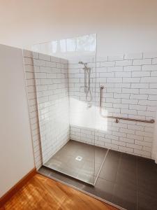 a bathroom with a shower with white tiles at Bellingdale Farm in Clothiers Creek