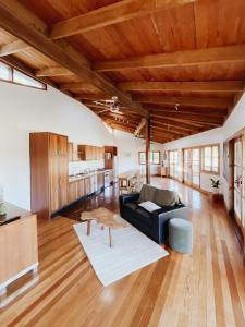 a living room with a black couch and wooden ceilings at Bellingdale Farm in Clothiers Creek