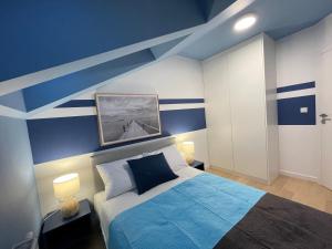a bedroom with blue walls and a bed with blue sheets at Apricot Sea View Premium Apartment in Władysławowo