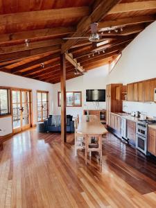 a large kitchen with wooden floors and a table at Bellingdale Farm in Clothiers Creek