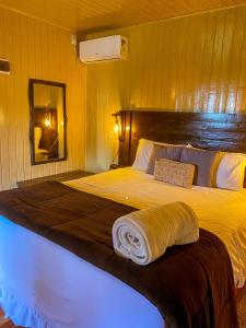 Un dormitorio con una cama grande con una manta. en Pousada Cardoso en Cambara do Sul