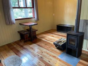 Habitación con estufa de leña y mesa. en Pousada Cardoso en Cambará