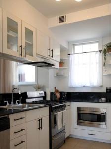 a kitchen with a sink and a stove top oven at Brand New Stylish 1BDR In Heart Of Rittenhouse Sq. Hosted By StayRafa in Philadelphia