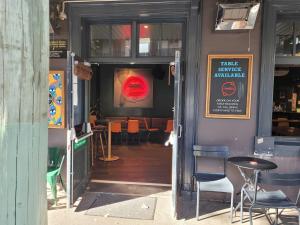 an open door to a restaurant with chairs and tables at Darlo Bar Darlinghurst in Sydney