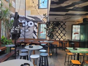 a room with tables and stools in a restaurant at Darlo Bar Darlinghurst in Sydney