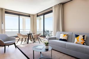 a living room with a couch and a table at Riviera Marriott Hotel La Porte De Monaco in Cap d'Ail