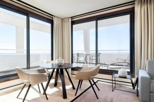 a dining room with a table and chairs and large windows at Riviera Marriott Hotel La Porte De Monaco in Cap d'Ail