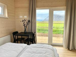 um quarto com uma cama, uma mesa e uma janela em REY Stays - Small & Cozy Studio em Höfn