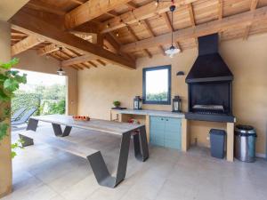 een keuken met een houten tafel en een fornuis bij Lavish Villa in Malauc ne with Private Garden in Malaucène