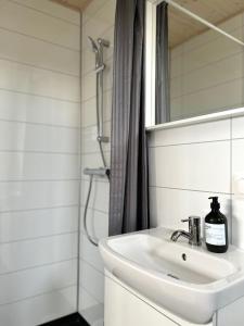 a white bathroom with a sink and a shower at REY Stays - Small & Cozy Studio in Höfn