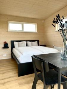 Un dormitorio con una cama y una mesa con un jarrón de flores en REY Stays - Small & Cozy Studio, en Höfn