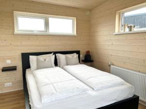 a large white bed in a room with two windows at REY Stays - Small & Cozy Studio in Höfn