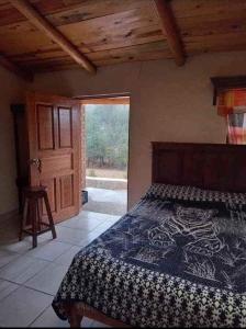 Areponapuchi的住宿－Cabañas De Lolita En Barrancas del cobre，一间卧室设有一张床和木制天花板
