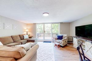 a living room with a couch and a flat screen tv at Mad River Mountain Getaway in Thornton