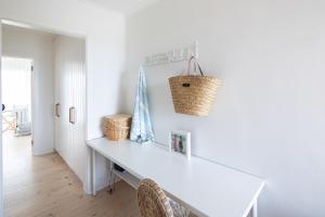 Port AdelaidePearl, Designer Beachfront Retreat, Semaphore Park的白色餐桌,墙上装有篮子