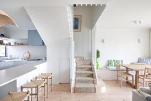 Port AdelaidePearl, Designer Beachfront Retreat, Semaphore Park的厨房里设有楼梯,配有桌椅