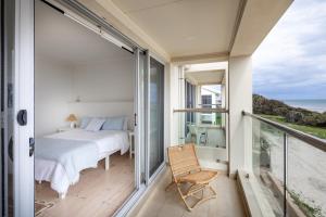 Port AdelaidePearl, Designer Beachfront Retreat, Semaphore Park的一间带床的卧室，可欣赏海景