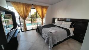 a bedroom with a bed and a large window at Katara Boutique Hotel in Mariquita