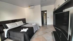 a bedroom with a bed and a flat screen tv at Katara Boutique Hotel in Mariquita