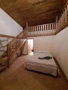 a bedroom with a bed and a wooden staircase at Cabañas De Lolita En Barrancas del cobre in Areponapuchi