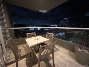 een tafel en stoelen op een balkon in de nacht bij HERMOSO!! MODERNO, UBICACION EXCLUSIVA!! 2 ALCOBAS in Barranquilla