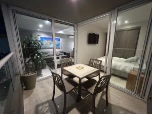 HERMOSO!! MODERNO, UBICACION EXCLUSIVA!! 2 ALCOBAS في بارانكويلا: طاولة صغيرة وكراسي في غرفة مع غرفة نوم