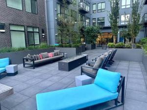 a patio with blue benches in front of a building at Downtown Glamorous Lifestyle in Tacoma The apartment near the convention center, Free Netflix , King size bed & futon sofa bed , AC, Great Amenities Rooftop, self-check-in in Tacoma