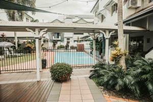 a patio with a fence and a swimming pool at Cairns Queens Court in Cairns