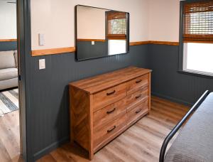 a bedroom with a dresser and a mirror at The Inn at the Gate in Skaneateles