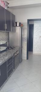 a kitchen with stainless steel appliances and a tile floor at Al Hoceima Bades in Al Hoceïma
