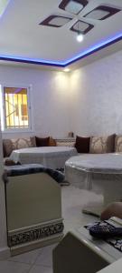 a room with three beds and a blue light at Al Hoceima Bades in Al Hoceïma